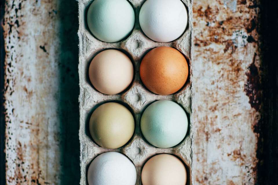 A carton of brown and white eggs, with no people in the frame