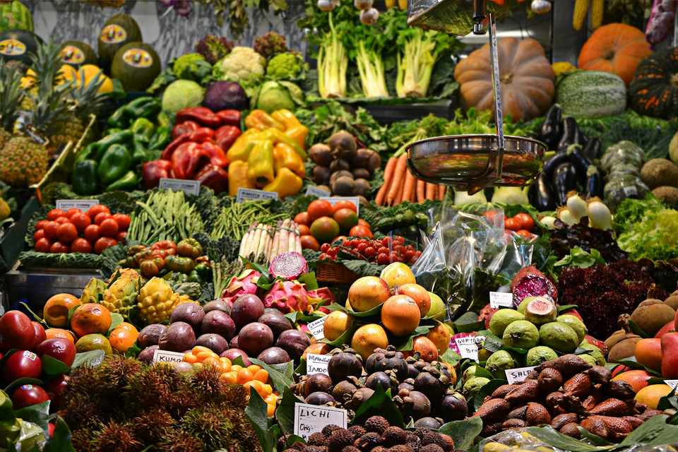 A produce stall piled with vegetables and fruit, with no people in the frame